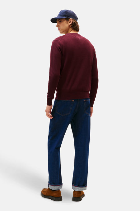 Veste Bordeaux TOMMY HILFIGER avec col rond, portée avec un chapeau bleu marine, des jeans noirs et des chaussures marrons, dos.