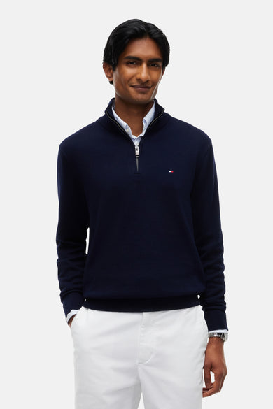 Pull à col roulé bleu marine TOMMY HILFIGER avec fermeture éclair, petit logo sur la poitrine, porté sur une chemise blanche, vue de face
