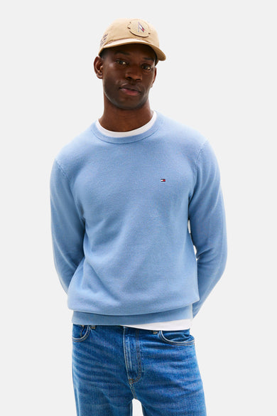 T-shirt bleu avec col rond de TOMMY HILFIGER, à manches longues et associé à une casquette de baseball, des jeans et des chaussures marrons.
