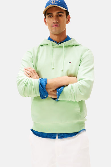 Sweater vert de Tommy Hilfiger avec capuche, vu avec une pantalon blanc et un chemisier bleu, vu de dos.