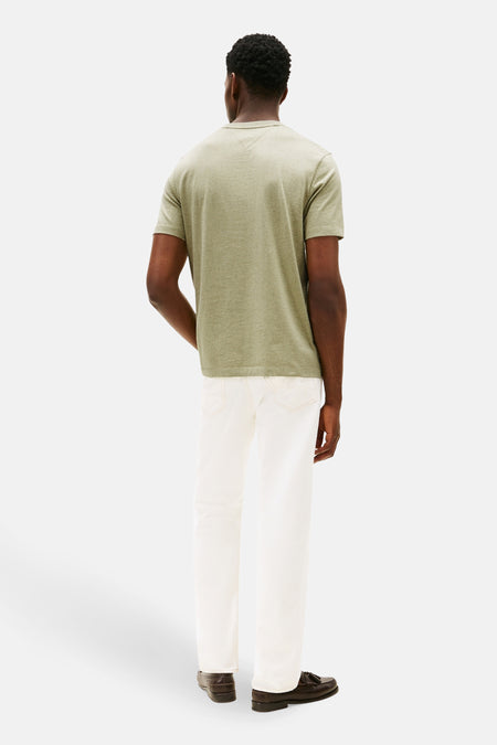 T-shirt vert de man man manman TOM TOM Tommy H H H Hger, vué derrière, combiné avec un pantalon blanc et des loafers marrons.