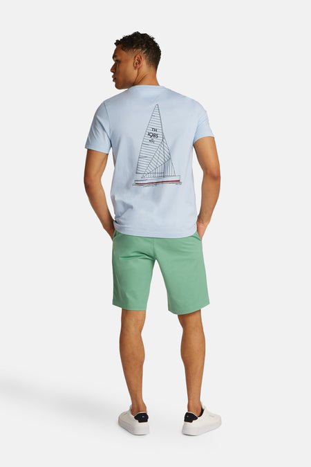 T-shirt à manches courtes bleu clair de TOMMY HILFIGER avec imprimé de voilier dans le dos, porté dans une mise en scène lifestyle