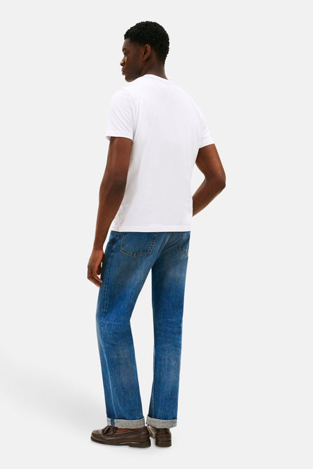 Wit T-shirt met korte mouwen van TOMMY HILFIGER, op de rug gezien, gecombineerd met blauwe jeans en bruine instappers.