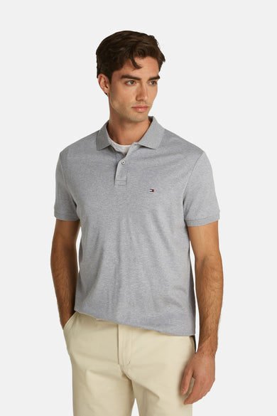Polo gris de TOMMY HILFIGER avec petit logo sur la poitrine, texture rayée, manches courtes, vue de face du modèle en pantalon beige