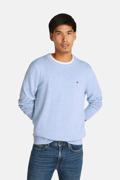 Pull à col rond bleu clair de TOMMY HILFIGER avec col blanc et petit logo sur la poitrine, porté avec un jean bleu, vue de face