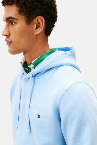 Sweat-shirt bleu avec capuche de Tommy Hilfiger, avec une deuxième patte de col et des cordons.