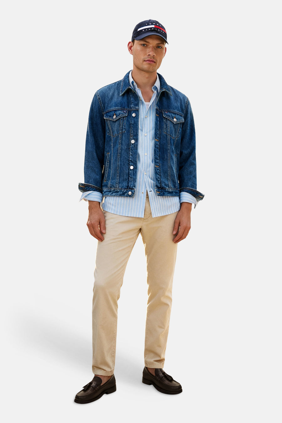 Chino beige de TOMMY HILFIGER, porté par un homme avec une veste en jean, une chemise rayée et des mocassins marron foncé.