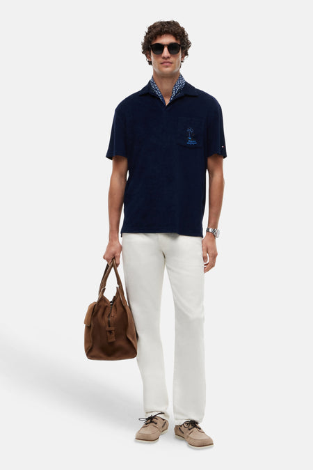 Polo bleu en tissu éponge de TOMMY HILFIGER avec poche poitrine et palmier brodé.