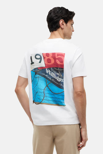 Witte korte mouw T-shirt van TOMMY HILFIGER met kleurrijke 1985 print op rug, zijaanzicht model