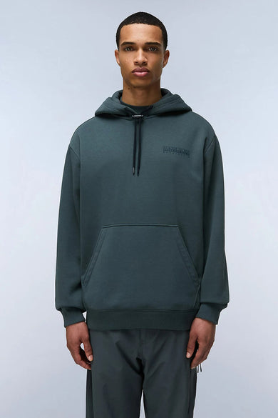 Pull-over vert de NAPAPIJRI avec un capuchon, une poche à l'avant, porté avec un pantalon coordonné.