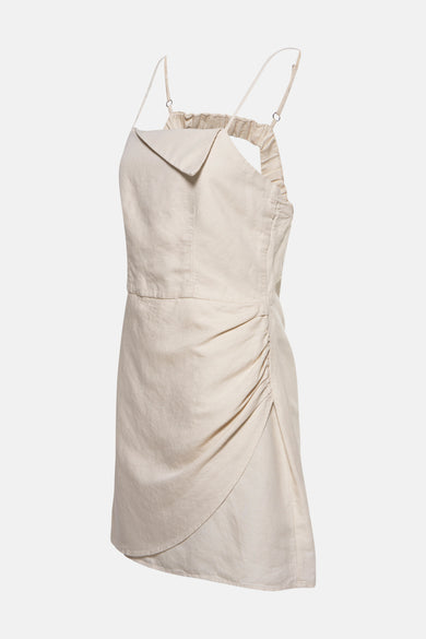Petite robe écru d'OXXO, avec des rubans spaghetti et des détails froncés sur les côtés.