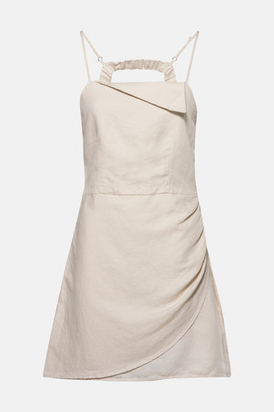 Crème court manteau OXXO avec des fines bretelles et une jupe drapée.