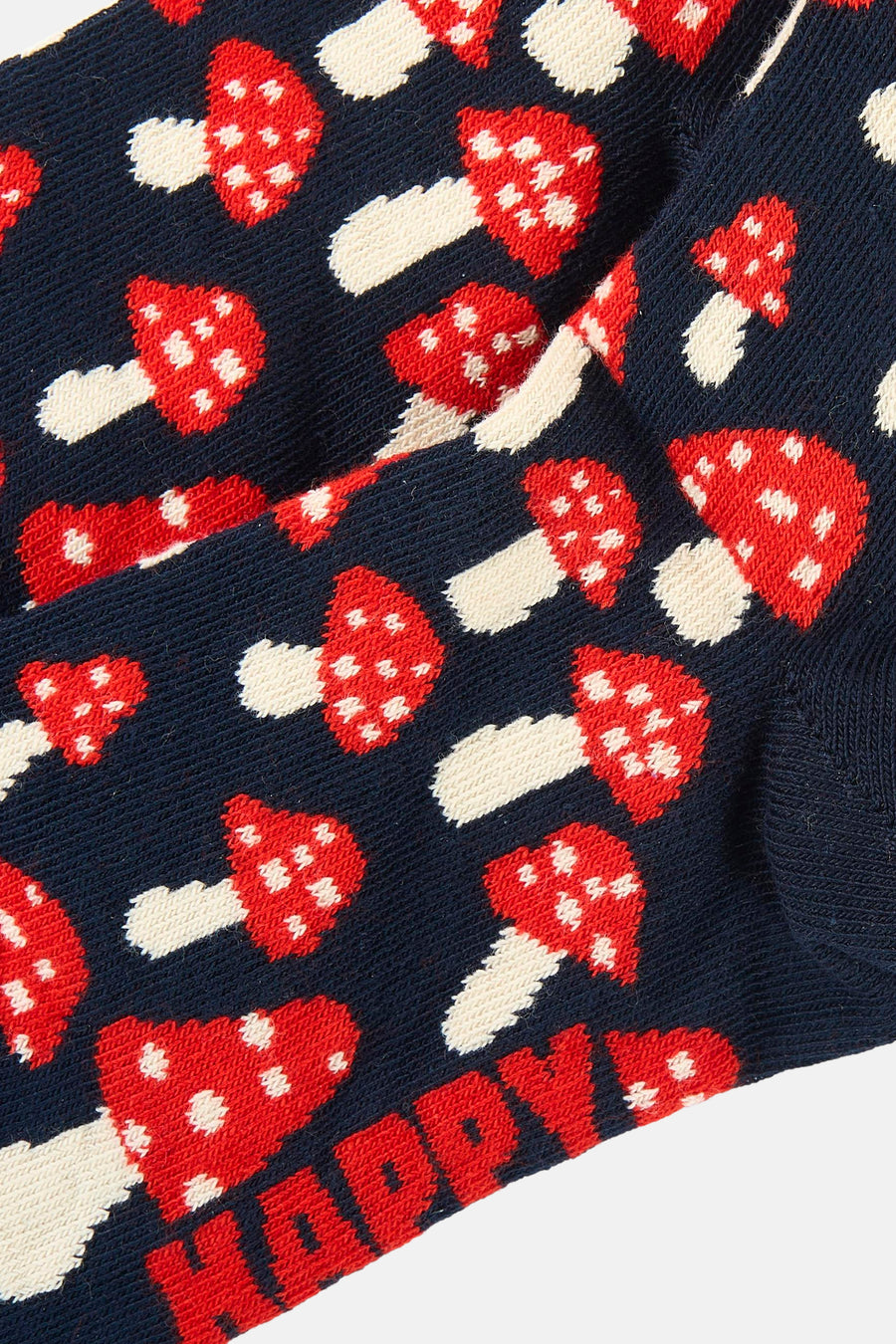 Blauwe sokken van Happy Socks® met een patroon van rode paddenstoelen en deels zichtbare tekst 'HAPPY'.