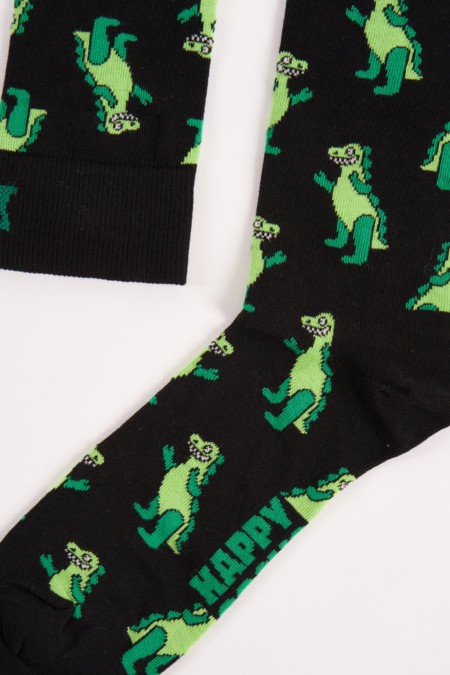 Chaussettes noires de Happy Socks, avec un motif de dinosaure vert et le mot "HAPPY" imprimé dessus.