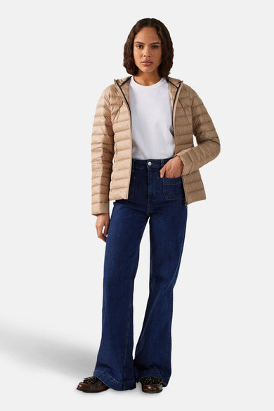 Manteaux de pluie beige de JOTT, portés avec un t-shirt blanc et des jeans larges avec des chaussures marron.