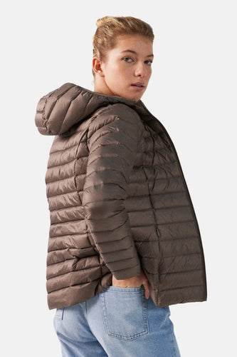 Bruine gewatteerde jas met capuchon, blauwe jeans, model staat op witte achtergrond.
