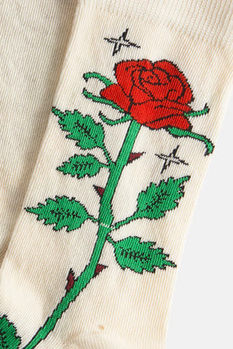 Ecru sokken van Happy Socks, met een geborduurde rode roos en doornen, en kleine zwarte kruisjes.
