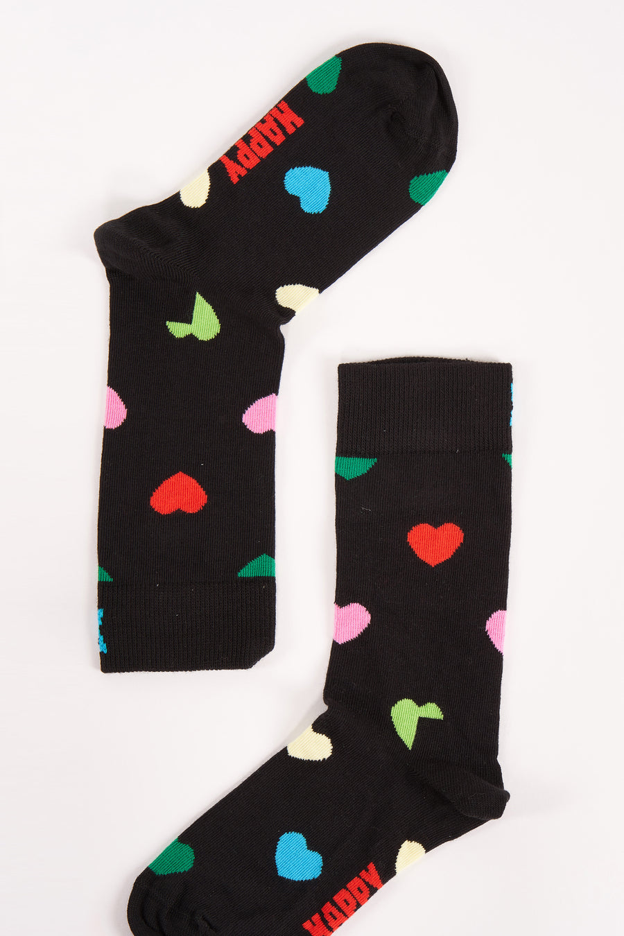 Chaussettes noires de Happy Socks, décorées de cœurs colorés et du texte 'Happy'.