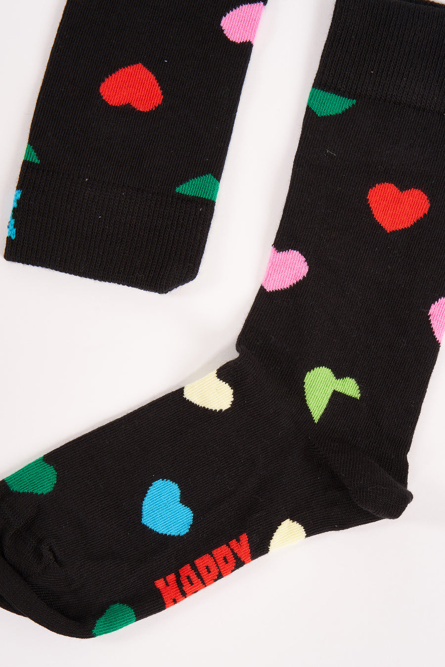 Zwarte sokken van Happy Socks, versierd met kleurrijke hartjes en de tekst 'Happy'.
