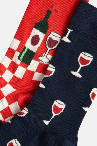 Chaussettes multicolores de Happy Socks® avec des bouteilles et des carafes de vin sur un fond rayé rouge et blanc.