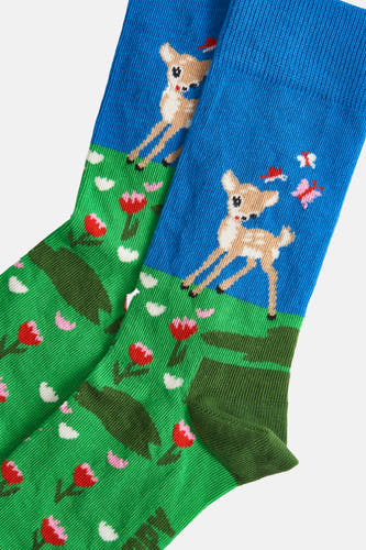 Chaussettes multicolores de Happy Socks® avec un motif de cerfs, de fleurs et de papillons sur un fond bleu et vert.