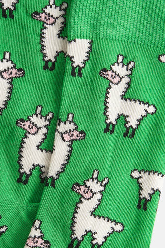 Chaussettes vertes de Happy Socks® avec un motif de lamas blancs pixelisés, une vue rapprochée.