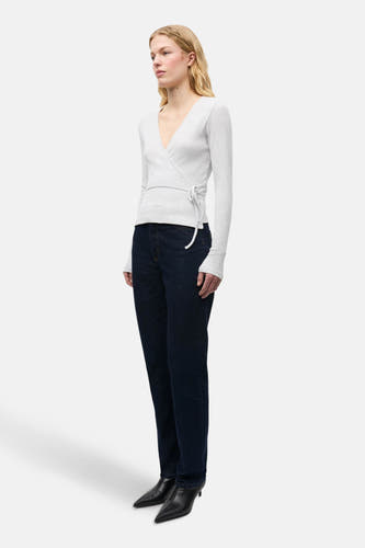 T-shirt gris à manches longues d'ENVII, avec poche et fermeture éclair, associé à des jeans bleu marine et des baskets noires.