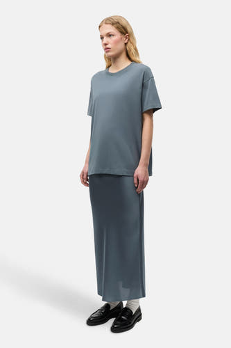 Blauw T-shirt met korte mouwen van ENVII, gedragen met een lange rok en zwarte schoenen.