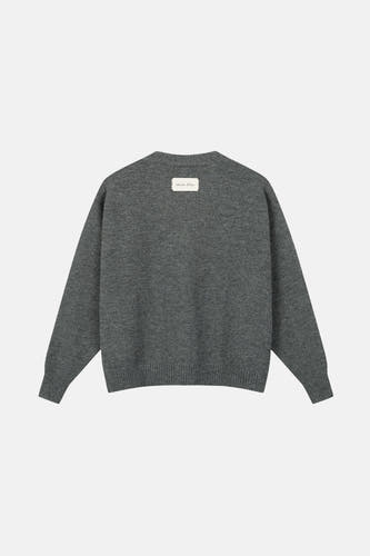 Gilet gris d'ANOTHER COTTON LAB, avec un étiquette dans le cou, sur un fond uni.
