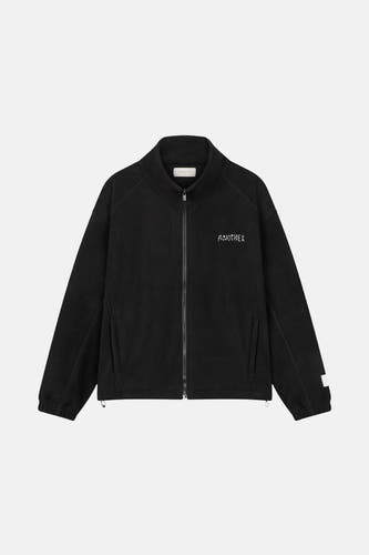Veste noire d'ANOTHER COTTON LAB avec fermeture éclair et le mot "ANOTHER" dessus.