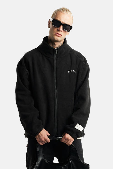 Veste noire d'ANOTHER COTTON LAB, avec fermeture à glissière et logo subtil sur la poitrine.