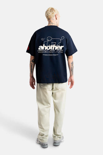 T-shirt bleu à manches courtes d'ANOTHER COTTON LAB, avec du texte blanc et un chien sur le dos.