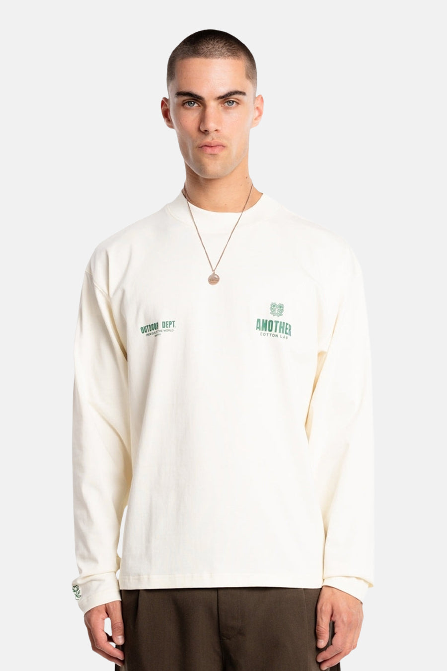 T-shirt écru à manches longues de ANOTHER COTTON LAB, avec logos verts sur la poitrine et la manche.