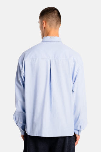 Chemise bleue à manches longues de ANOTHER COTTON LAB, vue de dos, avec un design uni et des plis soignés.