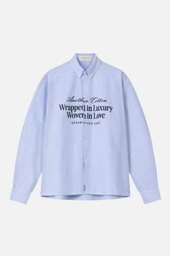 Chemise bleue à rayures à manches longues d'Another Cotton Lab, avec un imprimé texte sur le devant.