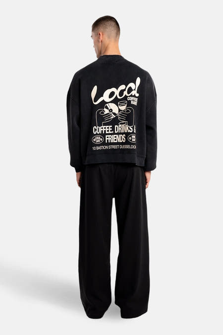 Sweat-shirt noir d'ANOTHER COTTON LAB avec imprimé graphique blanc "Local Coffee Rave" dans le dos.