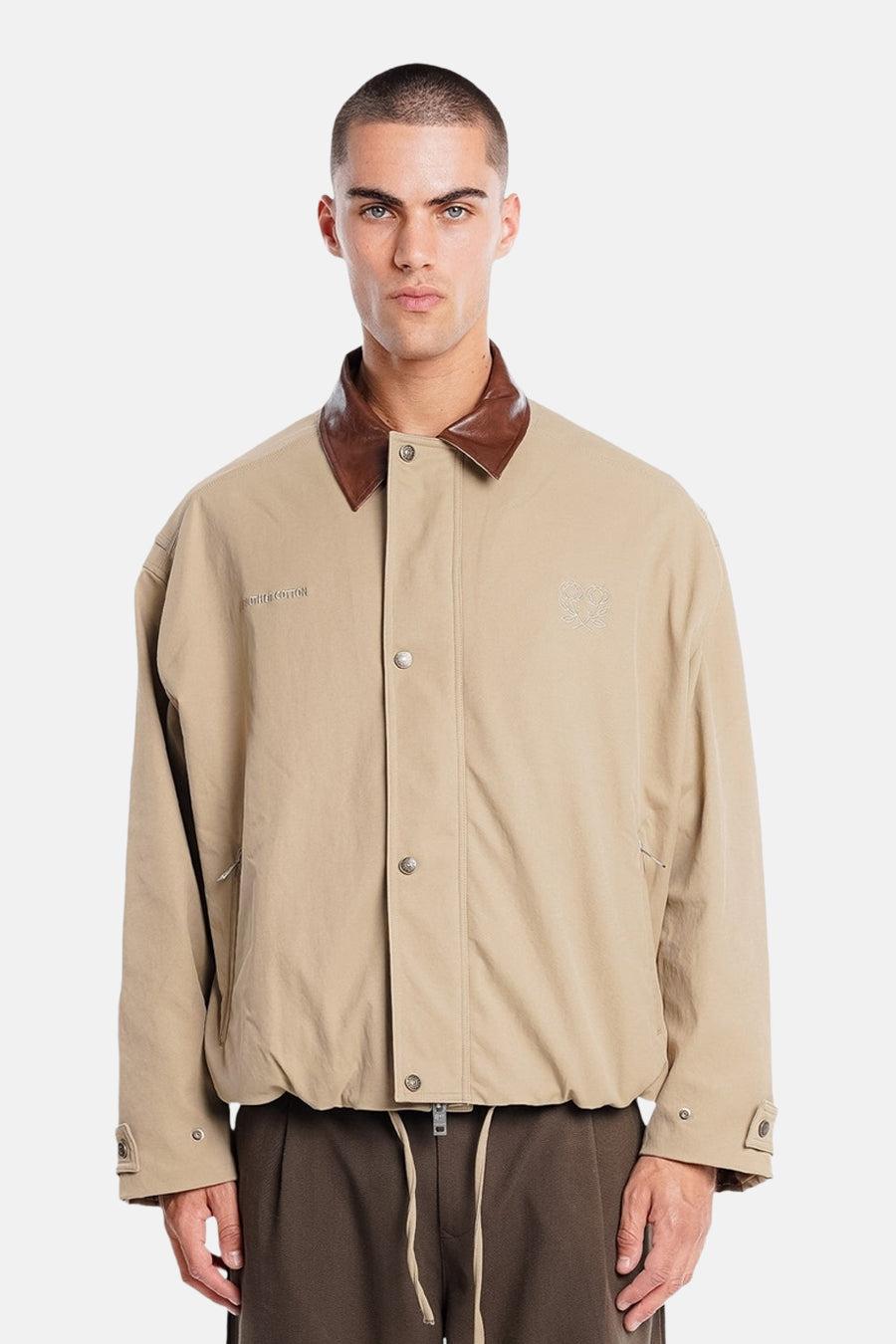 Manteau court beige de ANOTHER COTTON LAB, avec col marron et écusson dans le dos.