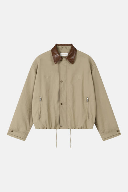Manteau court beige de ANOTHER COTTON LAB, avec col en cuir marron et logo brodé.