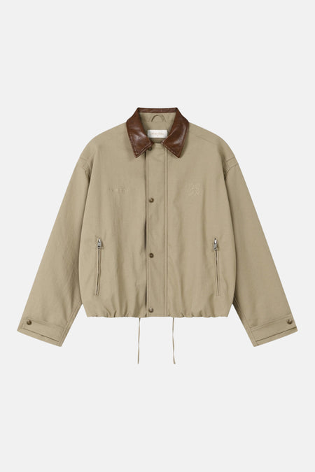 Manteau court beige de ANOTHER COTTON LAB, avec col en cuir marron et logo brodé.
