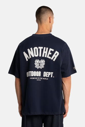 T-shirt bleu à manches courtes de ANOTHER COTTON LAB, avec texte blanc et un emblème floral dans le dos.