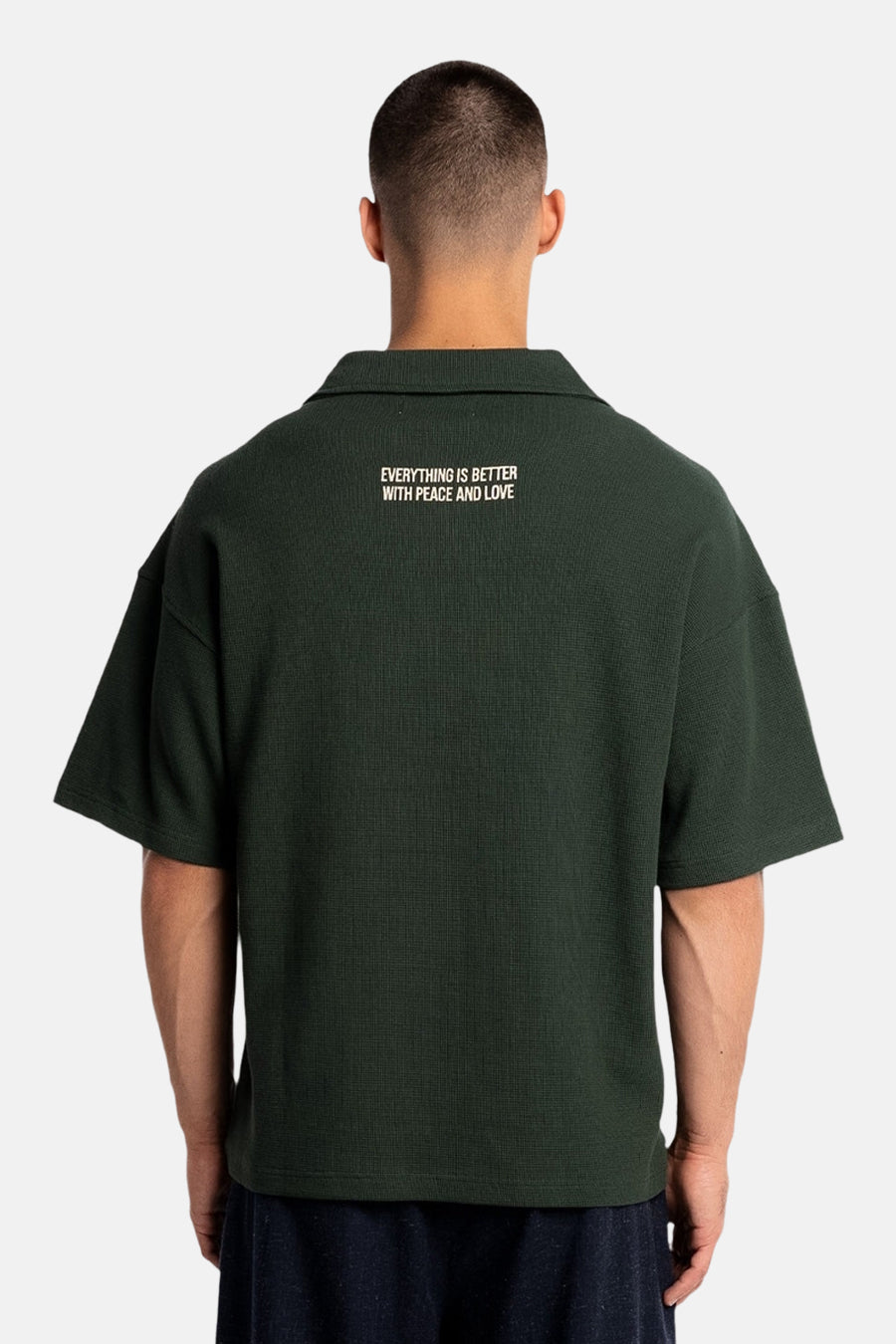 Polo verte à manches courtes de couleur verte de ANOTHER COTTON LAB, avec un imprimé texte au dos.
