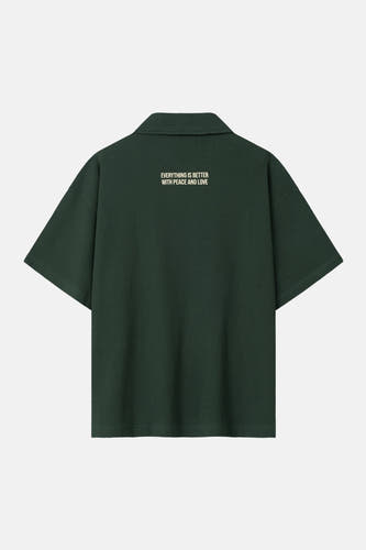 Polo verte à manches courtes de couleur verte de ANOTHER COTTON LAB, avec une texture fine et un imprimé texte au dos.