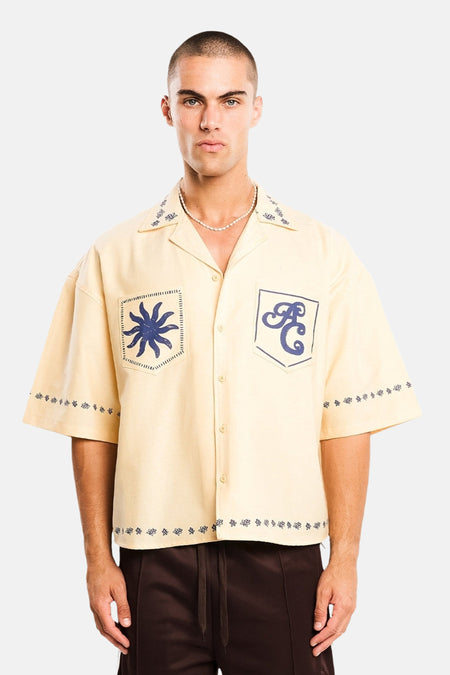 Geel katoenen overhemd met korte mouwen van ANOTHER COTTON LAB, voorzien van blauwe borduursels en logozakken, front view.