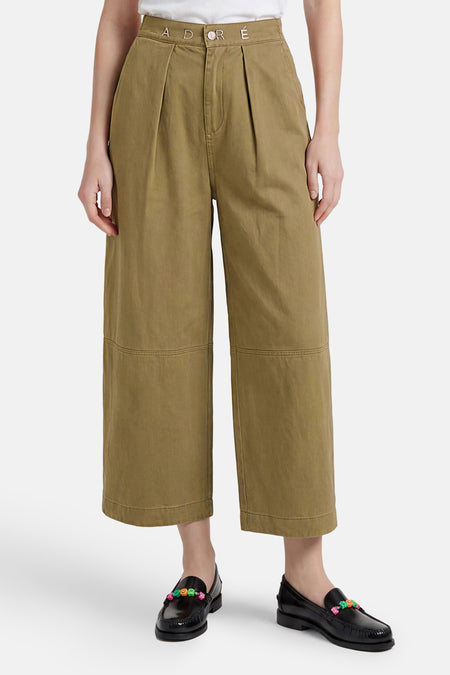 Groene chino broek van ADORE met hoge taille, plooien en geborduurd logo op tailleband, breed model tot enkel, voorzien van zakken en opgerolde zoom, front view.