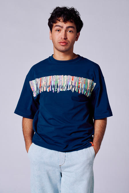 T-shirt bleu à manches courtes de Rock Werchter 50, dos avec petit logo et jeans bleu clair.