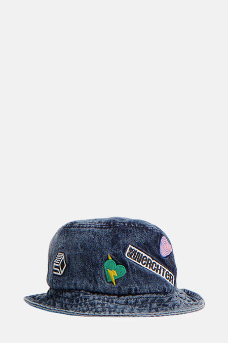 Blauwe hoed van Rock Werchter 50 met verschillende patches, waaronder een hart met een bliksemschicht en de tekst "WERCHTER".
