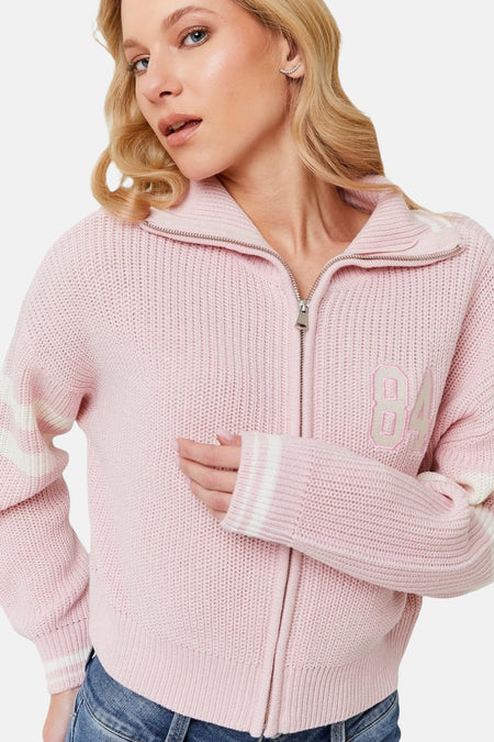 Roze vest met rits, lange mouwen met witte strepen, en nummer 84.