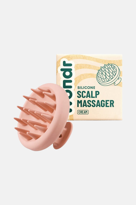Produit de soin rose de WONDR CARE, avec des points en silicone, à côté de l'emballage du produit.
