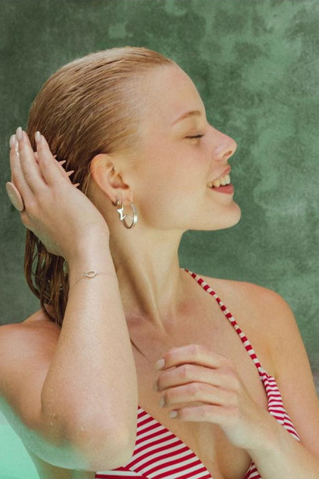 Produit de soin rose de WONDR CARE, avec un modèle dans une chemise à carreaux.