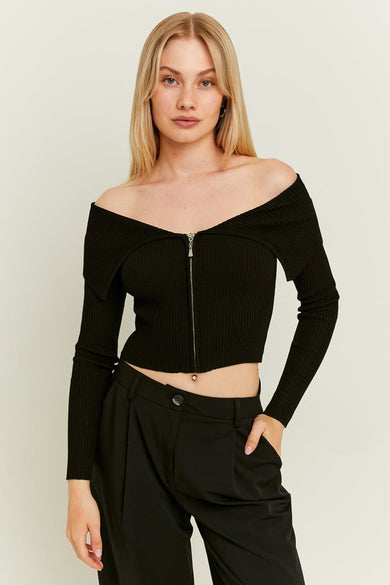Gilet noir de TALLY WEIJL avec longues manches et fermeture éclair, associé à un pantalon noir.